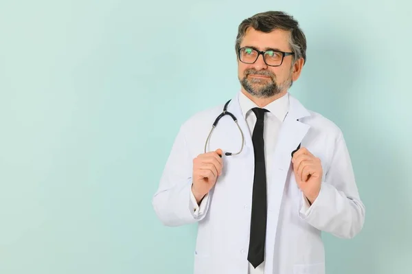 Senior Arts Draagt Stethoscoop Medische Jas Blauwe Achtergrond Vrolijke Uitdrukking — Stockfoto