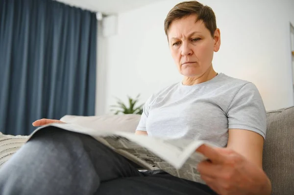 家で新聞を読んでいる女性 — ストック写真