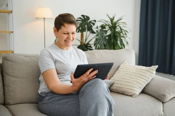 技术和互联网的概念 与平板 电脑在家里快乐的中年女子 — 图库照片