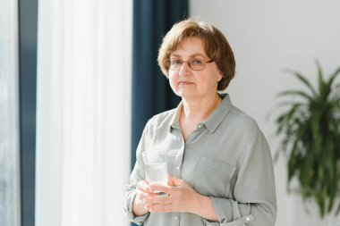 yaş, sağlık ve insan kavramı - evde su ile mutlu kadın kıdemli.