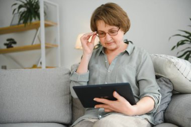 gülümseyen kadın kıdemli evde internet üzerinde bağlı.