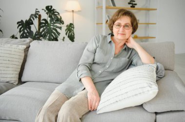 Düşünceli yaşlı bayan evde oturuyor, güzel anıları anımsıyor, portreyi kapatıyor..