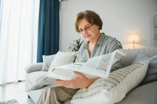 年龄和人概念 在家读报纸的快乐的资深妇女 — 图库照片