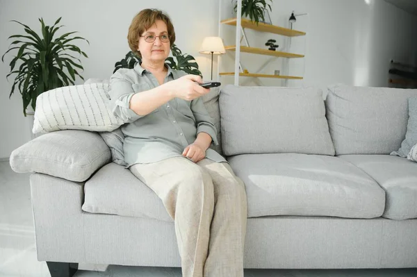 Mensen Televisie Entertainment Concept Senior Vrouw Brillen Met Afstandsbediening Thuis — Stockfoto