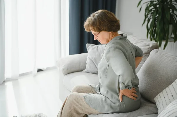 年老的时候 健康问题和人们观念 高级女人患背疼痛或在家的缰绳 — 图库照片