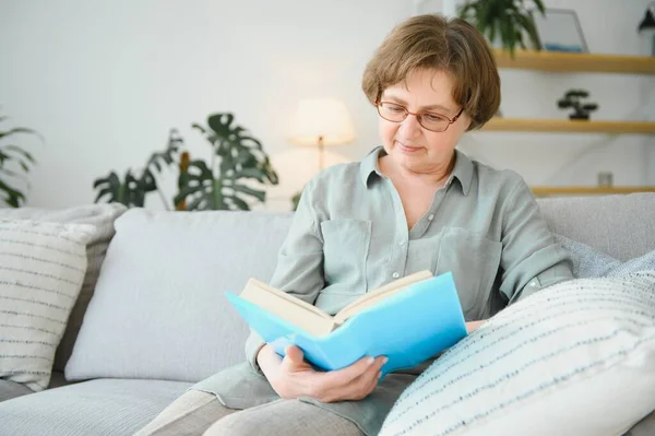 吸引人的 专心致志的 快乐的女人坐在迪文上的画像 在家里的公寓里看书消遣白日梦 — 图库照片
