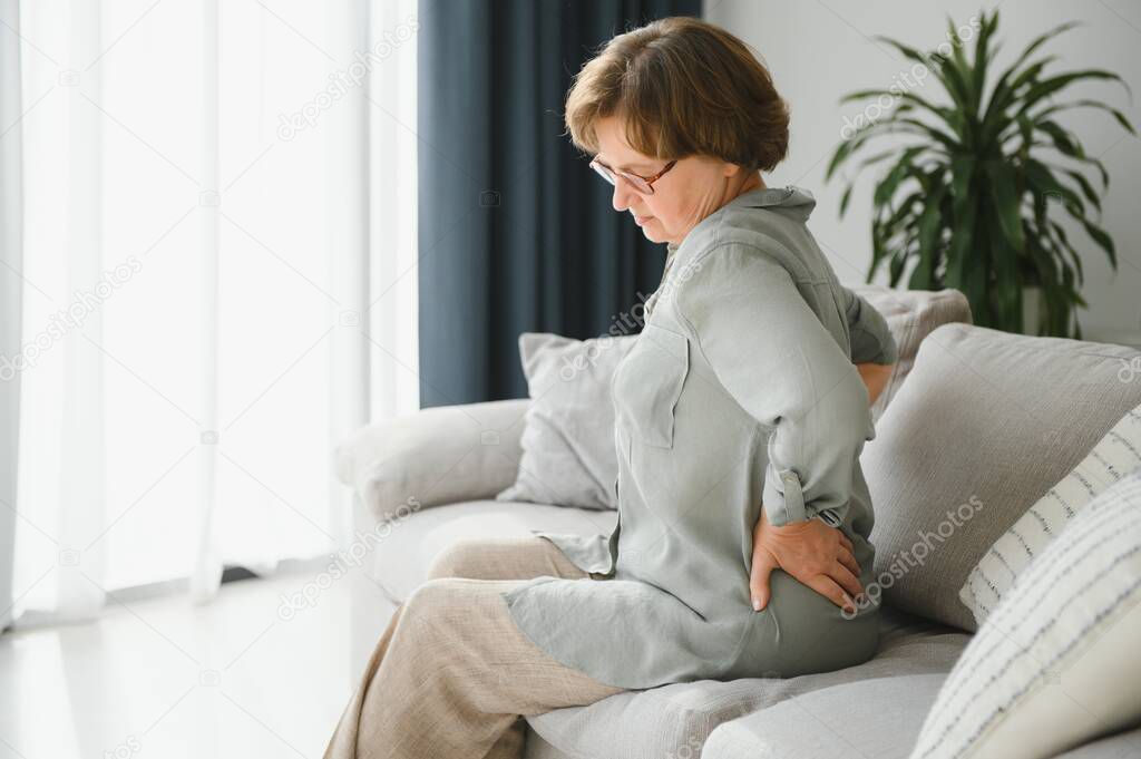 Senior woman suffering from backache at home.