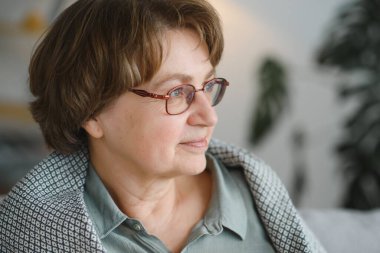 evde bir kanepede oturan rahat büyükanne