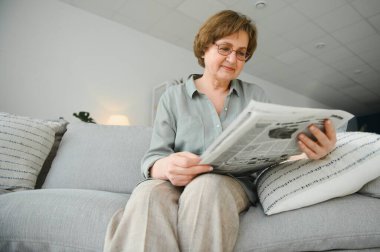 kadın gülümsüyor gazete ile yatak odasında.