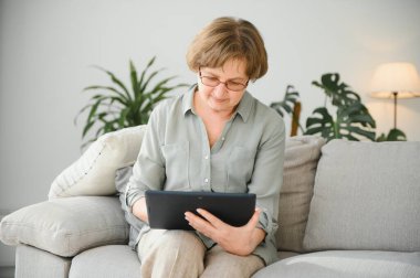 gülümseyen kadın kıdemli evde internet üzerinde bağlı.