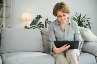 gülümseyen kadın kıdemli evde internet üzerinde bağlı.