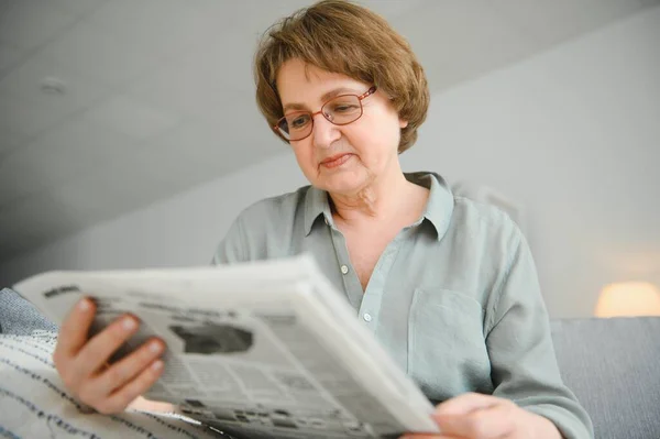老年妇女偷懒和看报纸 — 图库照片