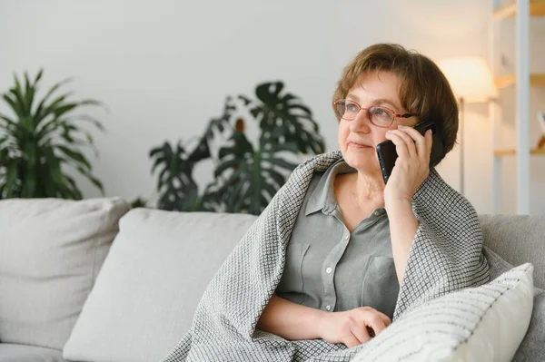 快乐地笑着 白俄罗斯老年老年老太太奶奶与朋友 孙子孙女 同事在手机上聊天 家里还在用智能手机 — 图库照片