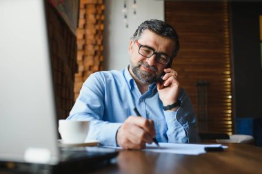 Kafe barda dizüstü bilgisayar kullanan bir adam..