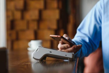 Olgun iş adamı NFC teknolojisiyle irtibatsız kredi kartıyla ödeme yapıyor.