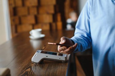 Olgun iş adamı NFC teknolojisiyle irtibatsız kredi kartıyla ödeme yapıyor.
