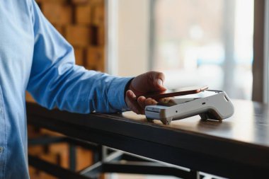 Olgun iş adamı NFC teknolojisiyle irtibatsız kredi kartıyla ödeme yapıyor.