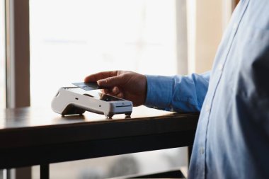 Olgun iş adamı NFC teknolojisiyle irtibatsız kredi kartıyla ödeme yapıyor.