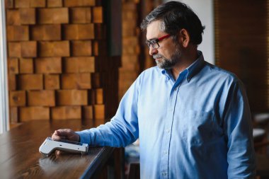 Olgun iş adamı NFC teknolojisiyle irtibatsız kredi kartıyla ödeme yapıyor.