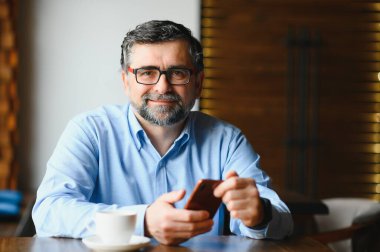 Kafede cep telefonu kullanan sıradan bir adam..