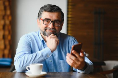 Kafede cep telefonu kullanan sıradan bir adam..