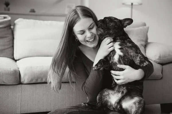 Young woman with her dog at home. Lovely pet.