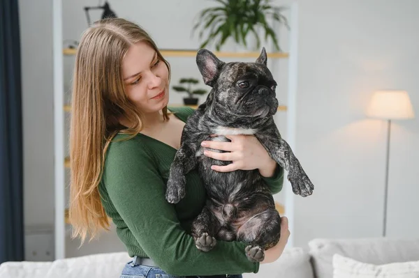 Kadın sahibi evde neşeli bir köpekle oynuyor. Köpek konseptiyle oynamak.