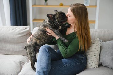 Kadın sahibi evde neşeli bir köpekle oynuyor. Köpek konseptiyle oynamak.