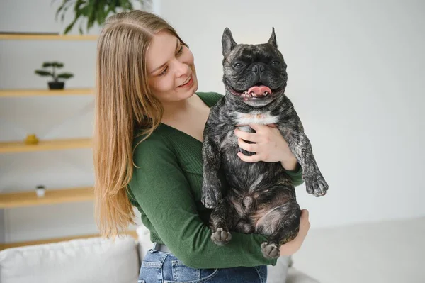 Young woman with her dog at home. Lovely pet.