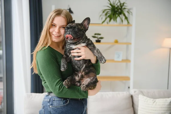 Female owner playing with joyful dog at home. Playing with dog concept.