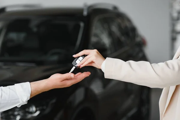 businessman exchange handing over the car keys for to a young women
