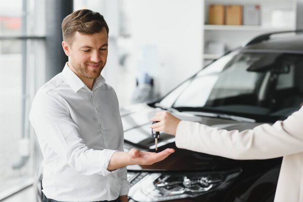 Man buying a car at a showroom.