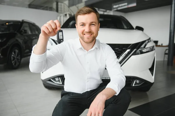 Man buying a car at a showroom.