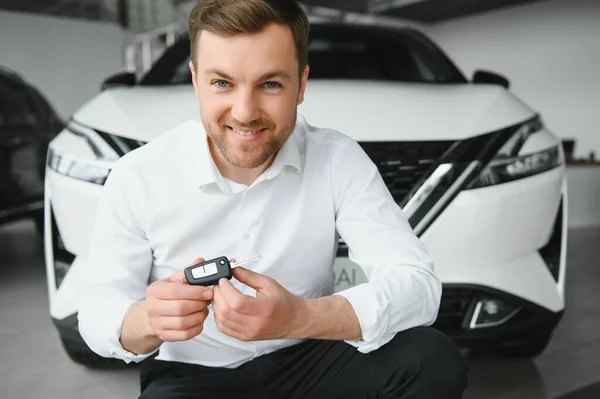 Man adult customer male buyer client wears classic suit white shirt chooses auto wants to buy new automobile touch check car in showroom vehicle salon dealership store motor show indoor. Sales concept