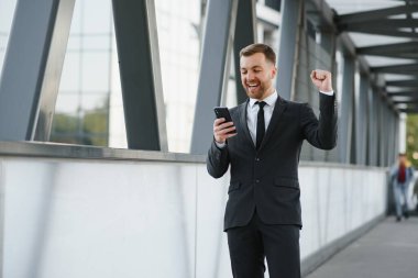 Arka takım elbise giymiş yakışıklı bir erkek model.