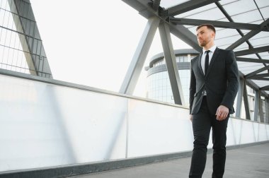 Arka takım elbise giymiş yakışıklı bir erkek model.