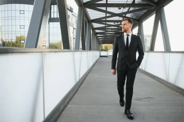 Arka takım elbise giymiş yakışıklı bir erkek model.