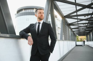 Arka takım elbise giymiş yakışıklı bir erkek model.