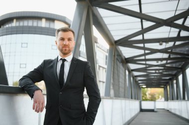 Arka takım elbise giymiş yakışıklı bir erkek model.