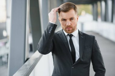 Arka takım elbise giymiş yakışıklı bir erkek model.