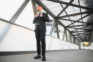 Arka takım elbise giymiş yakışıklı bir erkek model.