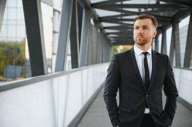 Arka takım elbise giymiş yakışıklı bir erkek model.