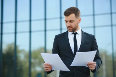 Takım elbiseli yakışıklı bir müdürün portresi, iş evrakları.