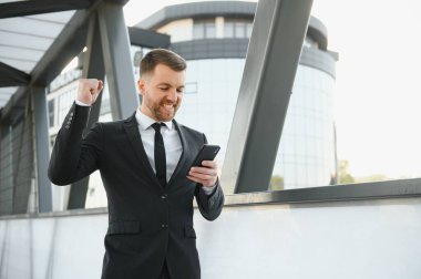 Genç adam resmi giyinmiş ve başarısının tadını çıkarıyor. Kazanan konsept.