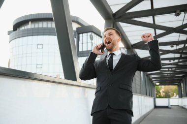 Başarılı bir iş adamı zaferini şehrin arka planında silahlı bir şekilde kutluyor.