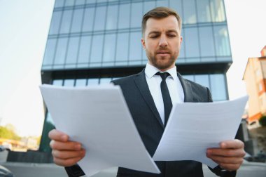 Takım elbiseli yakışıklı bir müdürün portresi, iş evrakları.