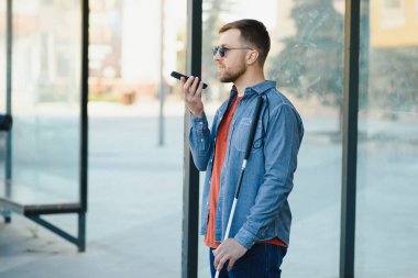 Kör adam. Özürlü, engelli ve günlük hayatı olan insanlar. Bastonlu görme engelli bir adam.