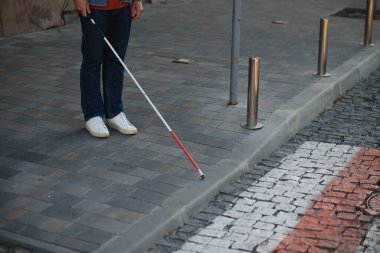 Beyaz bastonlu kör adam şehirde karşıdan karşıya geçiyor, yakın plan..