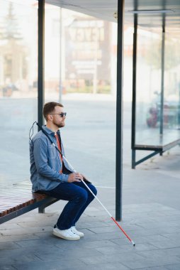Otobüs durağında otobüs bekleyen kör adam..