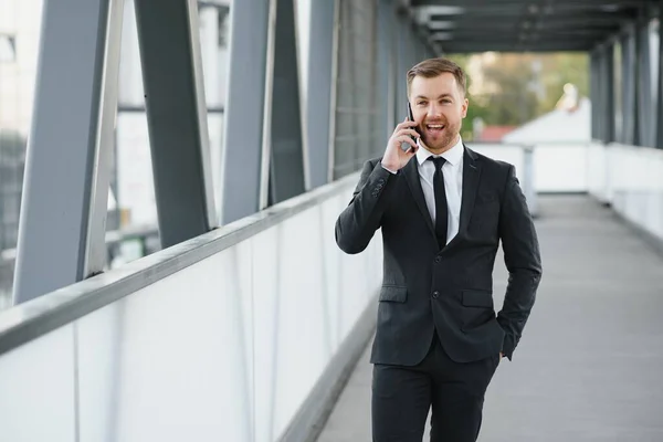 Businessman using smartphone in covered walkway